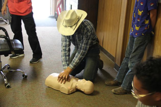 Chevy Novotny practices doing CPR on a mannequin. Photo by Pita Ainslie.