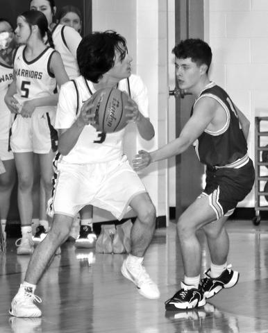 Photo by Mandy Scherer Malcolm Herman looks for an opening during junior varsity boys basketball play last Friday.