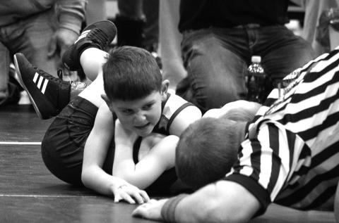 Photo by Melissa Slattery Kage Cook shows his determination as he waits for the ref to slap the mat at the Winner AAU meet on Sunday.