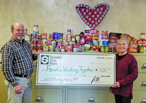 Photo submitted A Bank staff pictured with Feeding Hearts Food Drive donation items along with a $500 check to present to Families Working Together