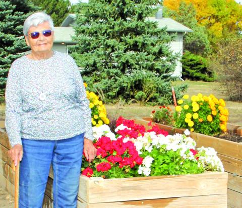 Photo by Chris Docter Marva stands proudly by her raised flower beds. Even now, she doesn’t spend much time sitting still.