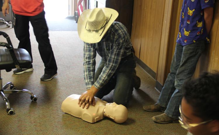 Chevy Novotny practices doing CPR on a mannequin. Photo by Pita Ainslie.
