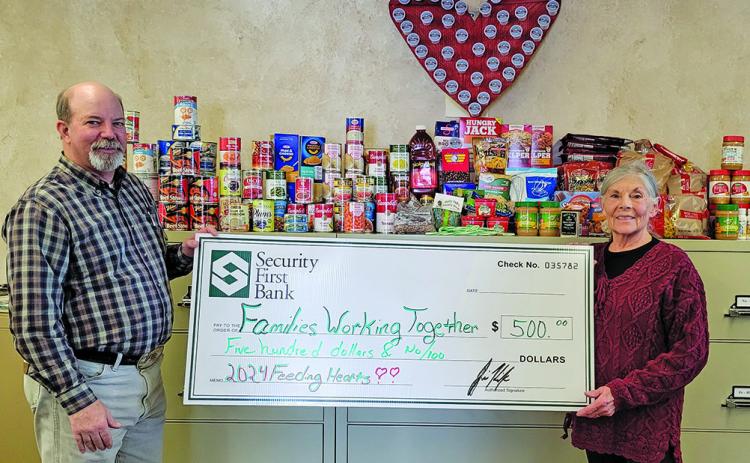 Photo submitted A Bank staff pictured with Feeding Hearts Food Drive donation items along with a $500 check to present to Families Working Together