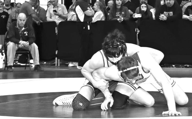 Photo by Mandy Scherer Coach Brent Ireland watches as Lyle Noel attempts to breakdown Aiden Schrempp in the first round of the 126 pound weight class at the state tournament.
