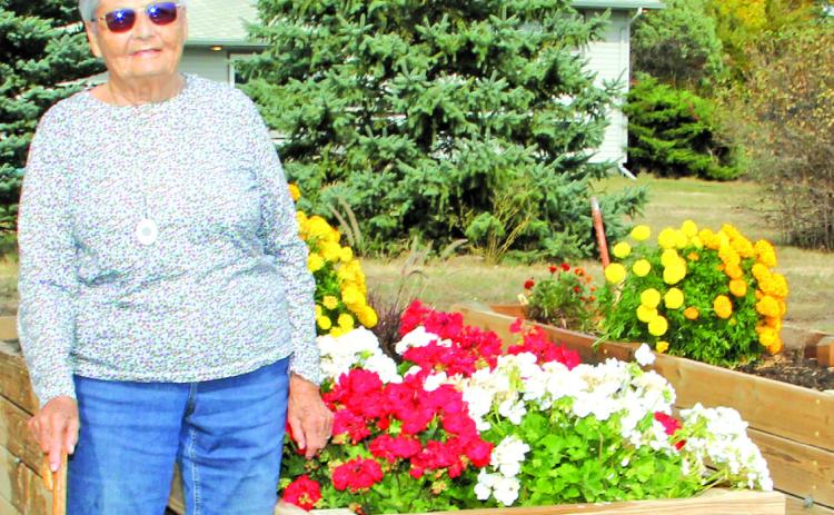 Photo by Chris Docter Marva stands proudly by her raised flower beds. Even now, she doesn’t spend much time sitting still.